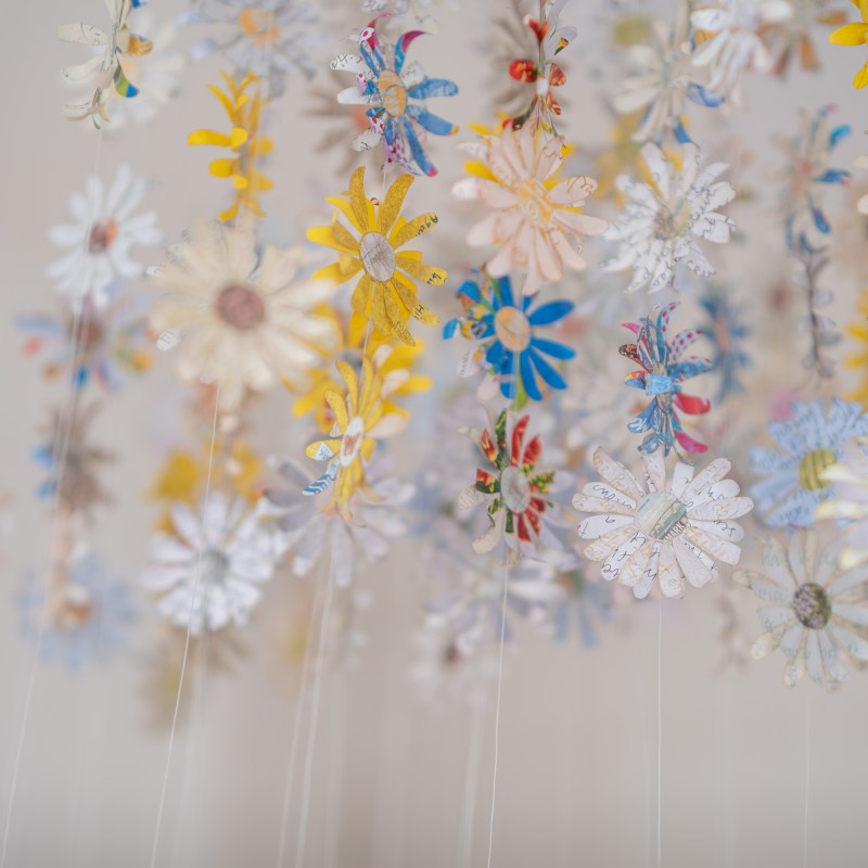 Picture of paper flowers hanging made from letters about the end of the danish postal service.